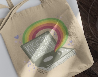 Op de afbeelding: Een beige tote bag met een regenboog en een platenspeler illustratie. De tekst op de platenspeler zegt "Muziek aan - wereld uit".