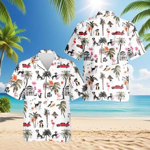 May include: White button-down shirt with a tropical print featuring black and white dogs, red convertibles, palm trees, and pink flamingos. The shirt has a classic collar and short sleeves, perfect for a summer day.