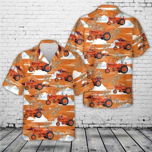 May include: Orange short-sleeved button-down shirt with a tractor pattern. The shirt features a repeating design of orange tractors, palm trees, and clouds on a light orange background. The shirt is displayed with a matching back.