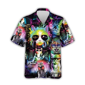 May include: Short-sleeved button-down shirt with a vibrant, colorful print featuring multiple cats wearing sunglasses and headphones. The design includes musical elements like speakers and DJ equipment, set against a dark, neon-lit background.