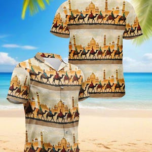 May include: Two short-sleeved button-down shirts with a desert-themed print. The shirts feature a repeating pattern of camels, riders, and buildings in shades of tan, brown, and beige. The background is a beach scene with blue sky and palm trees.