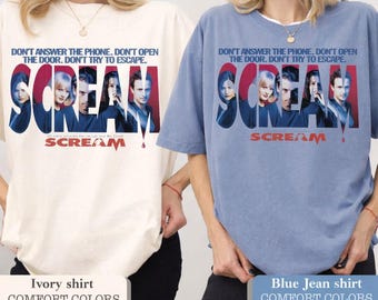 May include: Ivory and blue jean colored t-shirts featuring the movie title "Scream" with a graphic of the movie's cast. The text "DON'T ANSWER THE PHONE. DON'T OPEN THE DOOR. DON'T TRY TO ESCAPE." is printed above the title.