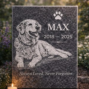 May include: A memorial stone with a detailed engraving of a Golden Retriever dog. The dog's name, "MAX", is above the years 2018-2025, with the text "Always Loved, Never Forgotten" below. A lit candle sits in front of the stone.
