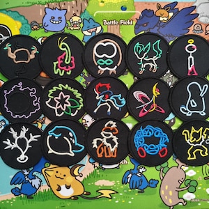 May include: A collection of fifteen circular black embroidered patches featuring neon-colored outlines of various creatures. Each patch displays a distinct character design in vibrant thread colors including pink, blue, yellow, white, and green.
