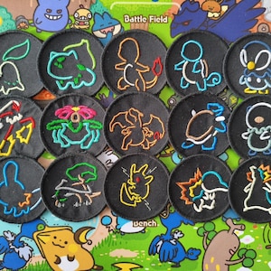 May include: A collection of embroidered patches featuring various cartoon characters in black circles. The characters are outlined in colors like green, orange, and blue. The background is a colorful cartoon scene.