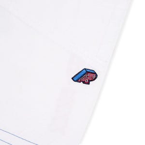 May include: White garment with a blue and red embroidered logo. The logo features the letters "AP" in a 3D design. The garment has visible stitching and a blue accent line.