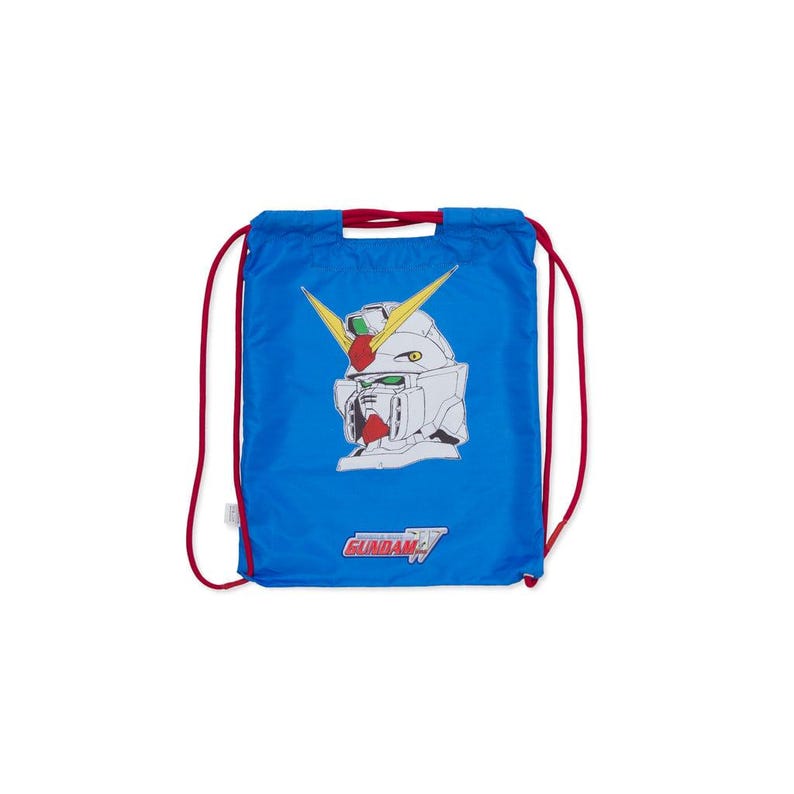 May include: Blue drawstring bag with a white and red Gundam robot head design. The bag has red drawstrings and the word "GUNDAM" printed at the bottom. The bag is made of a lightweight material.