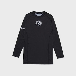 May include: Black long-sleeve athletic shirt with a crew neck. The shirt features a white circular logo on the chest and the word "que" on the left sleeve. The shirt is designed for athletic activities.