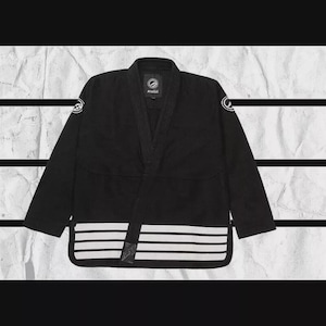 May include: Black Jiu-Jitsu uniform with white stripes on the bottom. The uniform has a V-neck collar and the brand logo on the chest and sleeves. The background is a textured, off-white paper.