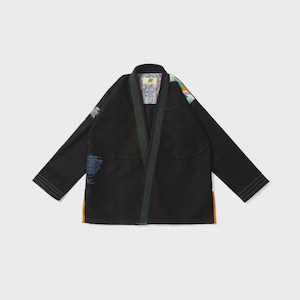Pode incluir: Gi de artes marciais preto com acabamentos verdes e detalhes coloridos nos ombros e gola. O gi apresenta um design tradicional com decote em V e mangas compridas. Possui um patch na manga esquerda e um design colorido no interior da gola.
