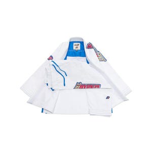 May include: A white martial arts uniform with blue and red detailing. The uniform features a jacket and trousers, with the word "GUNDAM" printed on the trousers. The jacket has a blue collar and lining.