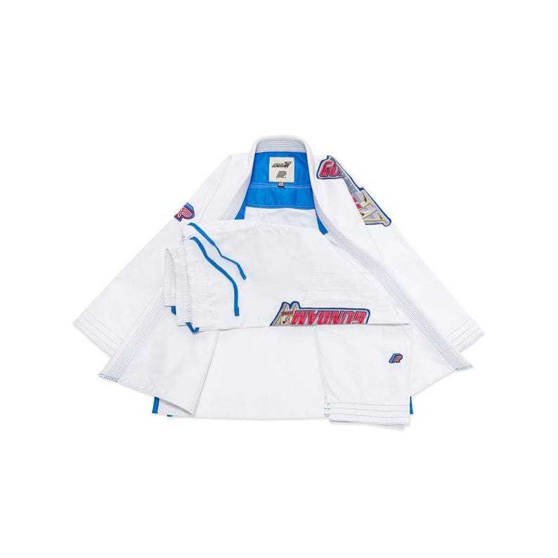 May include: A white martial arts uniform with blue and red detailing. The uniform features a jacket and trousers, with the word "GUNDAM" printed on the trousers. The jacket has a blue collar and lining.