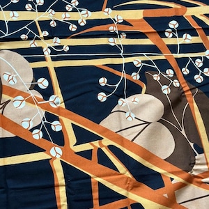 Może przedstawiać: Abstrakcyjny materiał z czarnym tłem, pomarańczowymi i żółtymi kształtami geometrycznymi i białymi wzorami kwiatowymi.