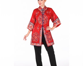 May include: A vibrant red tunic featuring a mandarin collar, three-quarter length sleeves, and intricate circular floral embroidery in shades of blue, pink, and gold. The garment has a front button closure with blue piping and black trousers.