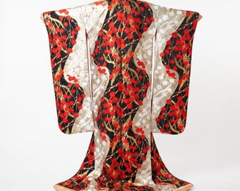 May include: A floor-length kimono featuring a bold pattern of vibrant red blossoms and thin gold branches set against a contrasting black and shimmering silver background. The garment has wide, extended sleeves and a structured, flared hemline.
