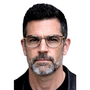 Puede incluir: Una taza de cerámica blanca con un asa negra y el texto "But First, Coffee" en un estilo manuscrito. La taza está sobre una superficie blanca. La taza mide aproximadamente 10 cm de alto.