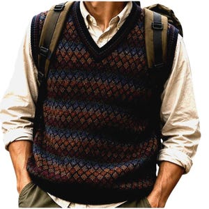 May include: A V-neck sweater vest with a diamond pattern in shades of brown, blue, and orange. The vest is layered over a light-colored button-down shirt. A backpack is worn over the shoulders.