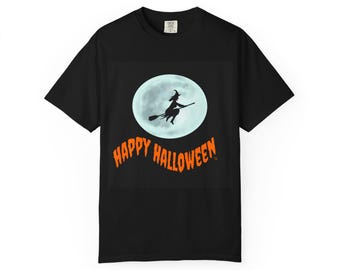Puede incluir: Camiseta negra con diseño de Halloween. El diseño presenta una bruja en una escoba frente a una luna llena. Las palabras "Happy Halloween" están en naranja, arqueadas en la parte inferior.