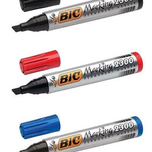 May include: Three BIC Marking 2300 permanent markers with black, red, and blue caps. The markers have a silver barrel with black ink tips. The BIC logo and "Marking 2300 PERMANENT MARKER" are printed on the barrel.