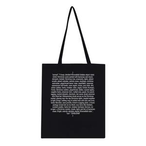 Könnte beinhalten: Schwarze Tragetasche mit weißer Grafik, die eine detaillierte Winterweihnachtsszene mit verschiedenen Feiertagselementen zeigt, darunter ein Weihnachtsbaum, Ornamente und der Weihnachtsmann. Der Text auf der Tasche beschreibt die Szene.