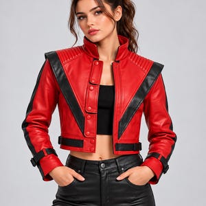 Puede incluir: Una chaqueta corta de cuero rojo con paneles de cuero negro en forma de V en la parte delantera, cuello alto, detalles acanalados en los hombros y correas con hebilla negras en los puños y la cintura. Cierre frontal con botones.