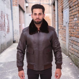 Puede incluir: Chaqueta bomber de cuero marr&oacute;n con cuello de piel marr&oacute;n oscuro. La chaqueta tiene dos bolsillos delanteros con botones, dobladillo y pu&ntilde;os de canal&eacute;. La chaqueta est&aacute; con cremallera y tiene un dise&ntilde;o cl&aacute;sico.