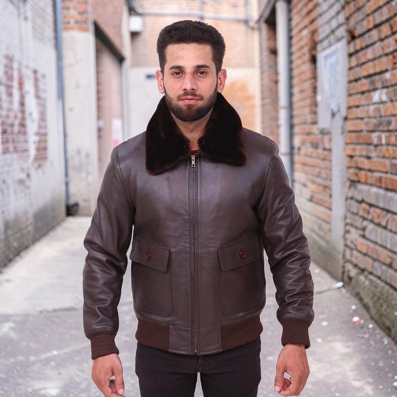 Puede incluir: Chaqueta bomber de cuero marr&oacute;n con cuello de piel marr&oacute;n oscuro. La chaqueta tiene dos bolsillos delanteros con botones, dobladillo y pu&ntilde;os de canal&eacute;. La chaqueta est&aacute; con cremallera y tiene un dise&ntilde;o cl&aacute;sico.