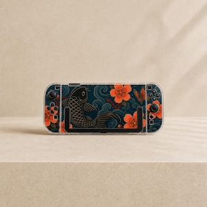 May include: A handheld gaming console featuring a protective case with a dark blue background, orange cherry blossoms, a black koi fish, and a butterfly. The device includes black joysticks, directional buttons, and a black kickstand on the back.