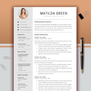 以下が含まれることがあります： 上部に「MATILDA GREEN」という名前の履歴書のテンプレート。履歴書には、職務経歴、プロジェクト、学歴、職務経験、出版物のセクションが含まれています。ペン、ペーパークリップ、バインダークリップが背景にあります。
