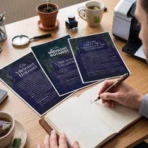 Puede incluir: Un escritorio de madera con un cuaderno, un bol&iacute;grafo y materiales impresos. El texto en los materiales impresos dice "The Midnight Botanist" y "Character Creation". Tambi&eacute;n hay una peque&ntilde;a planta en maceta, tinta y una taza de t&eacute;.