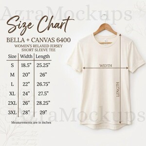 Pode incluir: Uma t-shirt de manga curta cor de creme pendurada num cabide de madeira, acompanhada por uma tabela de tamanhos para o modelo Bella + Canvas 6400. A tabela lista larguras e comprimentos em polegadas para os tamanhos S a 3XL, com setas.