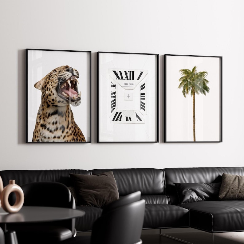 May include: Three framed art prints. The left print features a leopard with its mouth open. The center print has a clock design with the text "GIRL CLUB". The right print shows a palm tree. All prints have black frames.