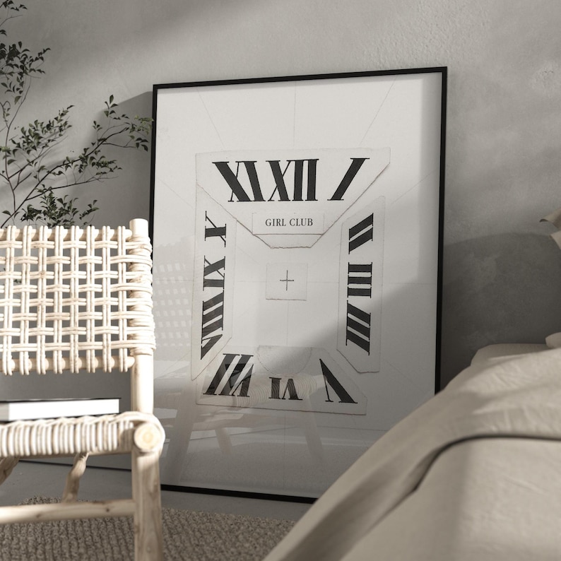 May include: A framed art print with a white background and a geometric design incorporating Roman numerals. The words "GIRL CLUB" are centered. The print is displayed in a room with a woven chair and a bed.