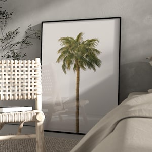 May include: A framed print depicting a palm tree illustration. The tree has a brown trunk and green fronds, set against a white backdrop. The artwork is enclosed in a black frame, suitable for home decor, with a minimalist aesthetic.