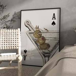 Puede incluir: Impresión artística enmarcada con un diseño de copa de Martini. La obra de arte representa un vaso de estilo mosaico lleno de aceitunas, con pequeñas figuras encima. El símbolo de la carta As de Picas es visible.