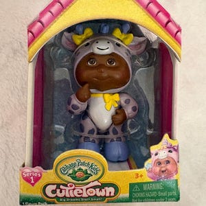 May include: A set of three ceramic mugs with a speckled, matte finish. The mugs are in shades of cream, light gray, and dark gray. Each mug has a simple, minimalist design and a rounded handle.