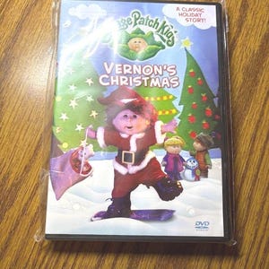 May include: A Cabbage Patch Kids DVD titled Vernon's Christmas. The cover features a doll dressed as Santa Claus on a snowboard, with other dolls, a snowman, and Christmas trees in the background. The text reads A Classic Holiday Story.