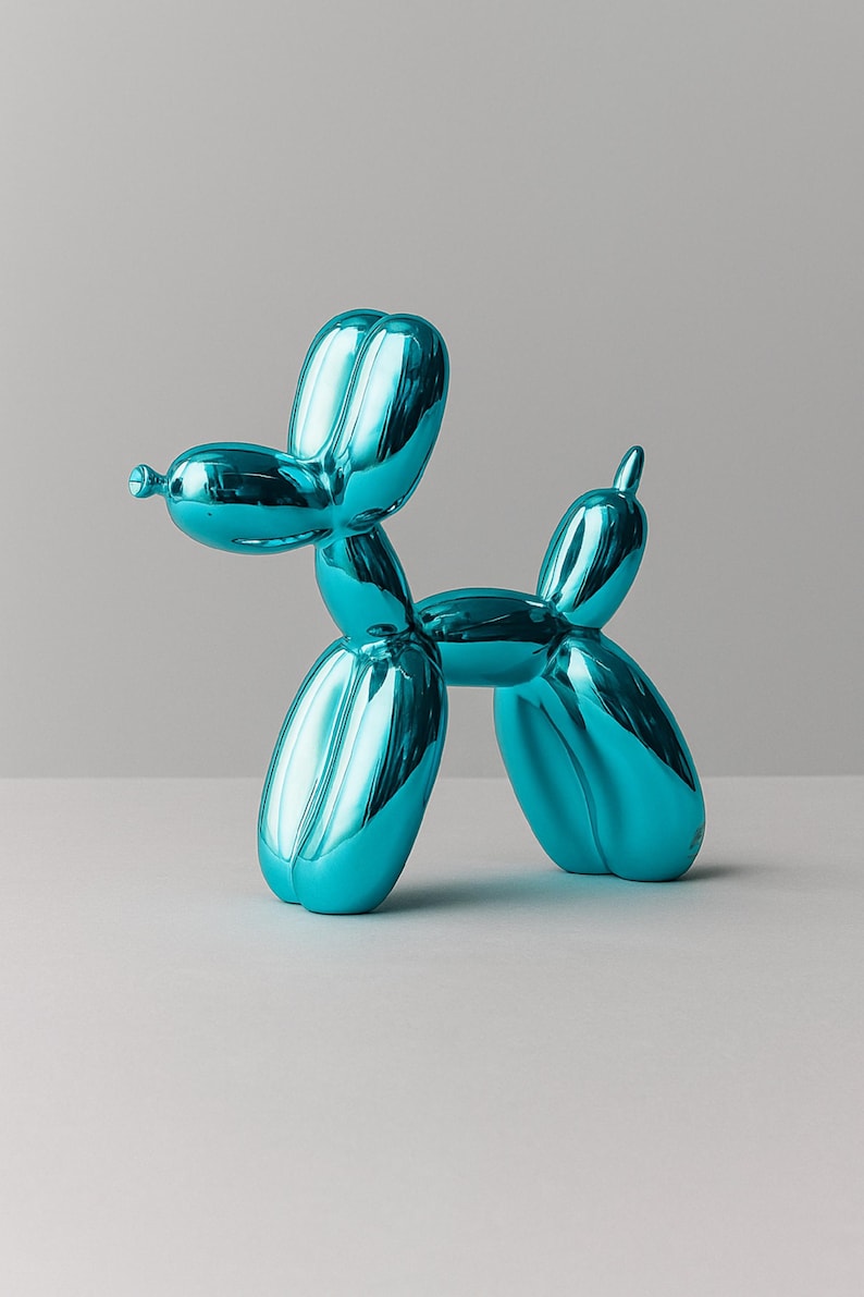 Op de afbeelding: Een glanzende, turquoise ballonhond sculptuur. De hond staat in een staande positie, gevormd uit opgeblazen ballonvormen. Het beeld heeft een reflecterende, metallic afwerking en is een decoratief item.