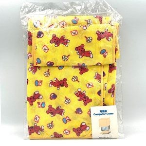 May include: A yellow computer cover featuring a repeating pattern of red teddy bears, small envelopes, and colorful lollipops. The item is enclosed in a clear plastic bag and includes a white label with the text Computer Cover and an illustration.