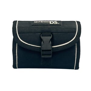 May include: Black Nintendo DS carrying case with white trim and a black buckle closure. The case has the Nintendo DS logo on the top. The case is rectangular and appears to be made of a durable fabric.