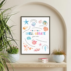 May include: A framed art print featuring colorful seashells and starfish illustrations. The text "SHELL-ABRATE your wins" is displayed in a playful font. Inspirational quotes surround the central design, creating a motivational piece.