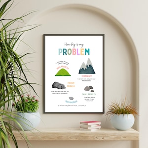 May include: Framed print with the text "How big is my PROBLEM" in colorful letters. The print illustrates problem sizes with graphics of a hill, mountains, rocks, and text descriptions. The print is displayed on a wooden shelf.