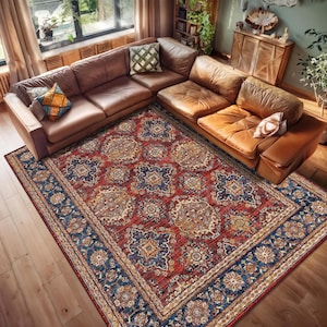May include: A rectangular area rug featuring a detailed floral and geometric pattern in shades of deep red, navy blue, and gold. The rug has a wide, ornate border with intricate motifs and a central field filled with repeating medallion designs.