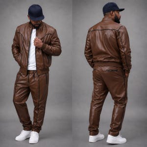 May include: A brown leather tracksuit, including a bomber jacket and matching pants, with black trim. The jacket has a zipper closure and the pants have pockets. The outfit is paired with a white t-shirt and white sneakers. A navy blue baseball cap completes the look.