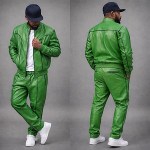 May include: A two-piece green leather tracksuit with black trim. The jacket is a bomber style, and the pants are straight-legged. The outfit is paired with a white t-shirt and white sneakers. A navy blue baseball cap completes the look.