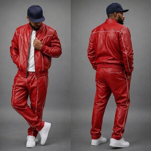 May include: A red leather tracksuit with white piping. The jacket has a zip closure and the pants have a drawstring waist. The outfit is worn with a white t-shirt and white sneakers. The person is wearing a navy blue baseball cap.