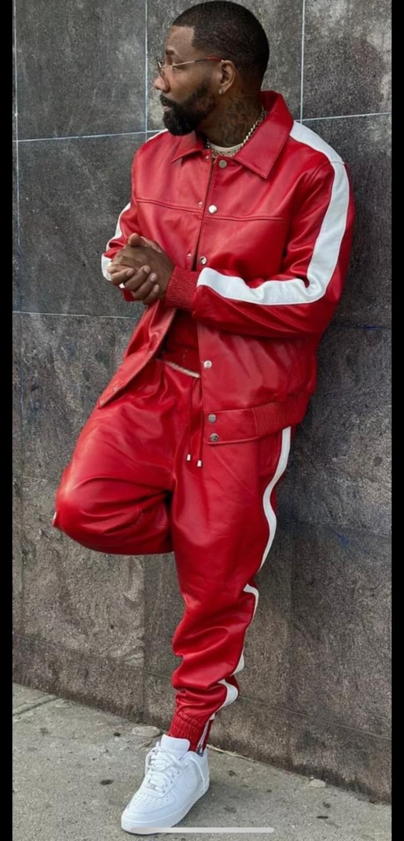 May include: A red leather jacket and matching pants with white stripes. The jacket has a collared neckline and button closures. White sneakers complete the outfit. The ensemble is a bold fashion statement.