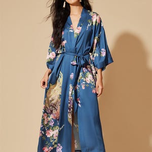 May include: A long, flowing blue robe with a floral pattern. The robe features a V-neck, wide sleeves, and a matching belt. The floral design includes pink and purple flowers with green leaves.