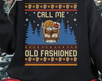 Op de afbeelding: Zwarte sweatshirt met een afbeelding van een Old Fashioned cocktail, met een sinaasappelschijfje en een kers. De tekst luidt "CALL ME OLD FASHIONED" in een feestelijk, vakantie-thema ontwerp. Het ontwerp bevat sneeuwvlokken en schedel- en rendierpatronen.