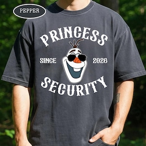 以下が含まれることがあります： 「PRINCESS SECURITY」の文字とサングラスをかけたオラフのイラストが描かれた濃いグレーのTシャツ。「SINCE 2026」の文字も含まれています。左上には「PEPPER」という文字が白い楕円で囲まれています。